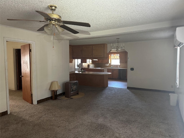 kitchen with pendant lighting, kitchen peninsula, sink, and dark colored carpet