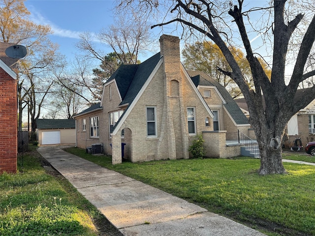 view of side of home with a garage, an outdoor structure, a yard, and central AC