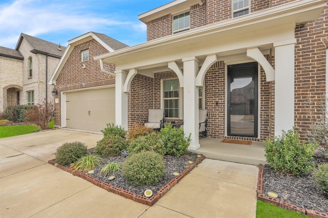 view of exterior entry featuring a garage and a porch