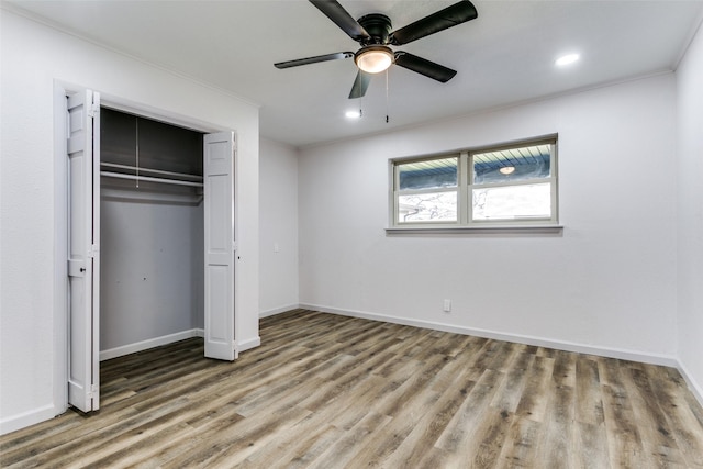 unfurnished bedroom featuring hardwood / wood-style flooring, a closet, and ceiling fan