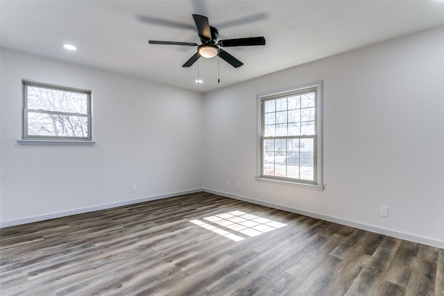 empty room with ceiling fan and dark hardwood / wood-style flooring