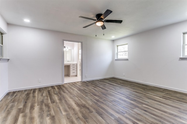 interior space with ensuite bath, dark hardwood / wood-style floors, and ceiling fan