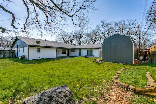 back of property with a storage shed and a lawn