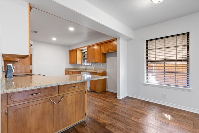 kitchen with dishwasher, range, dark hardwood / wood-style floors, light stone counters, and kitchen peninsula