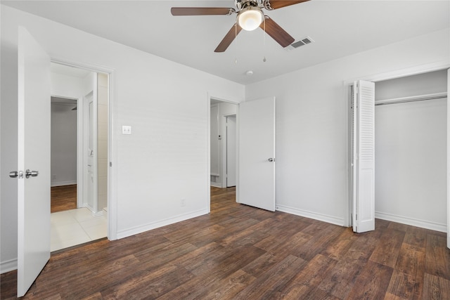 unfurnished bedroom with dark hardwood / wood-style flooring, a closet, and ceiling fan