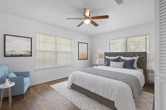 bedroom with ceiling fan, hardwood / wood-style floors, and multiple windows