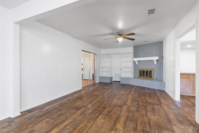 unfurnished living room with dark hardwood / wood-style flooring, a brick fireplace, and ceiling fan