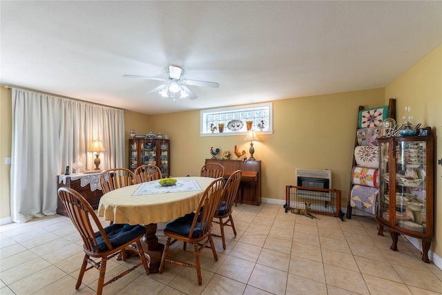 dining space featuring light tile patterned flooring, ceiling fan, and heating unit