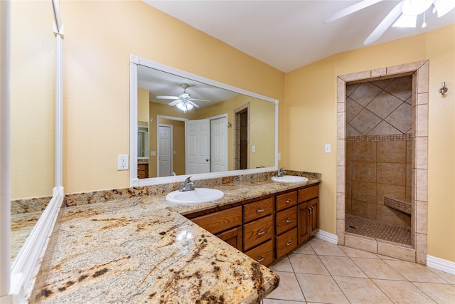 bathroom featuring ceiling fan, vanity, tile patterned flooring, and a tile shower