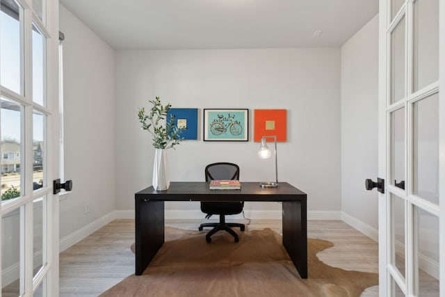 home office with light wood-style floors, baseboards, and french doors