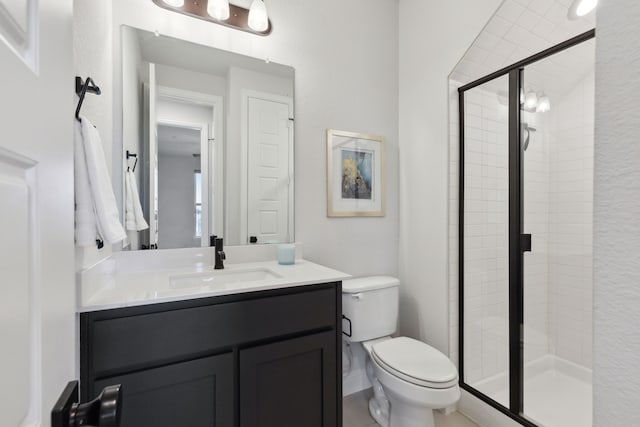 full bathroom with vanity, a shower stall, and toilet