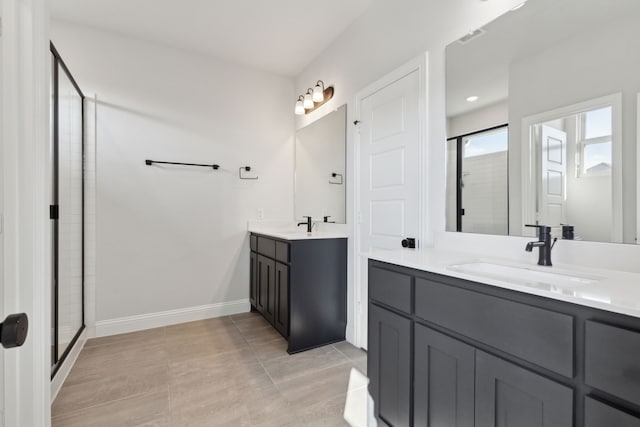 bathroom with two vanities, a stall shower, a sink, tile patterned flooring, and baseboards