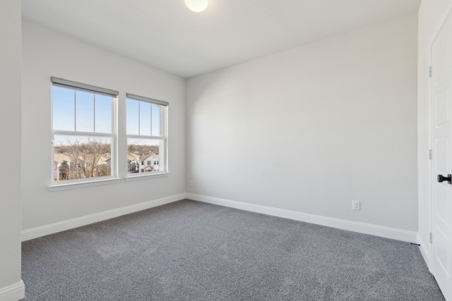 spare room with baseboards and carpet flooring