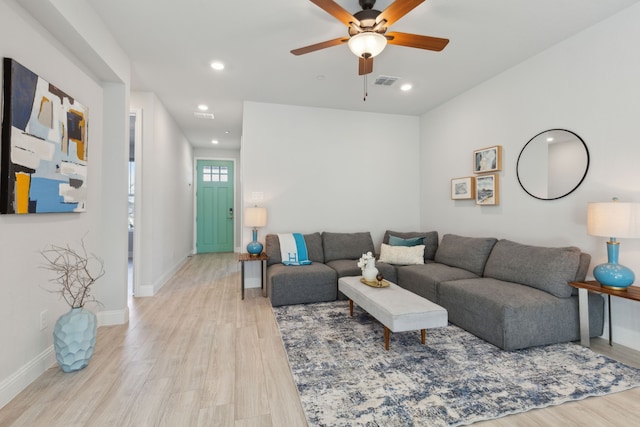 living room with light wood-style flooring, visible vents, baseboards, and recessed lighting