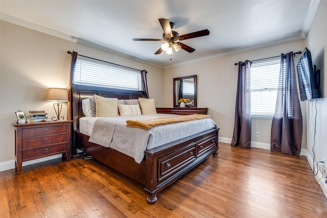 bedroom with crown molding, a ceiling fan, dark wood-type flooring, and baseboards