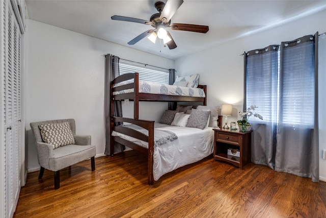 bedroom with a ceiling fan, multiple windows, and wood finished floors