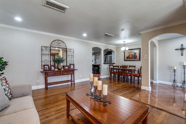 living room with arched walkways, visible vents, baseboards, and wood finished floors