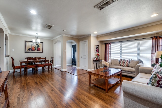 living room with visible vents, arched walkways, dark wood finished floors, and ornamental molding