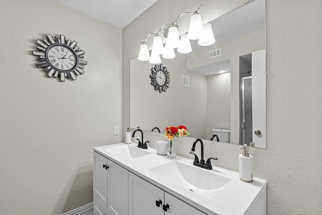 bathroom featuring vanity, toilet, and walk in shower