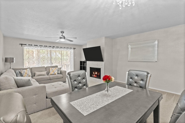 dining space featuring a textured ceiling, light carpet, and ceiling fan