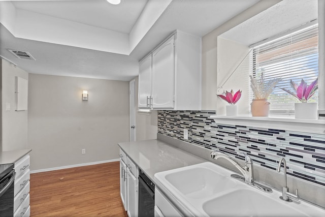 kitchen with sink, backsplash, dishwasher, light hardwood / wood-style floors, and white cabinets