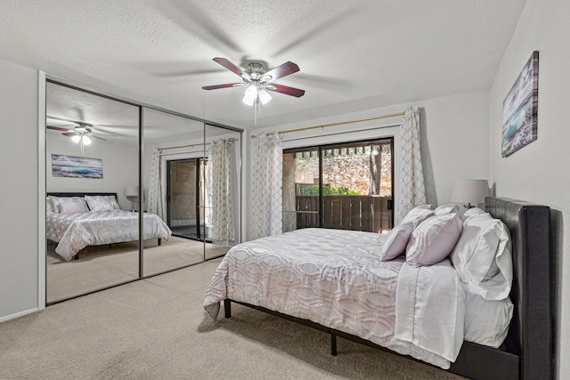 carpeted bedroom with ceiling fan, a textured ceiling, and a closet