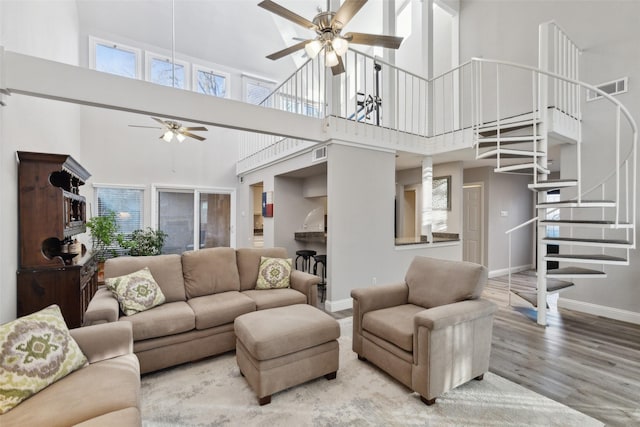 living room with ornate columns, ceiling fan, and light wood-type flooring