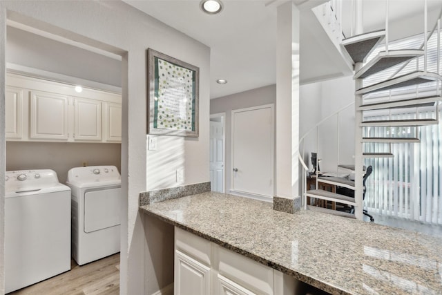 washroom with light wood-type flooring, cabinets, and independent washer and dryer