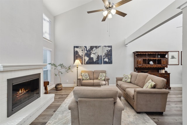 living room featuring wood-type flooring, ceiling fan, and high vaulted ceiling