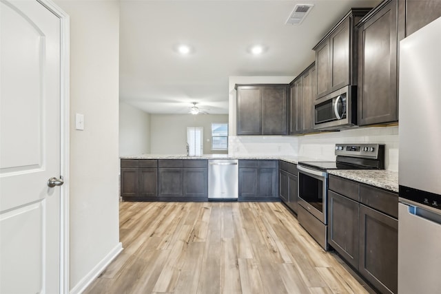 kitchen featuring light stone countertops, appliances with stainless steel finishes, and dark brown cabinets