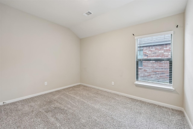 spare room featuring lofted ceiling, plenty of natural light, and carpet floors