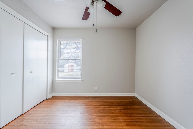 unfurnished bedroom featuring hardwood / wood-style flooring, a closet, and ceiling fan