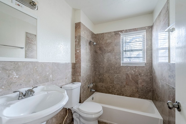 full bathroom featuring tile walls, sink, toilet, and tiled shower / bath