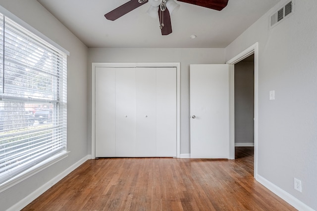 unfurnished bedroom with ceiling fan, a closet, and light wood-type flooring