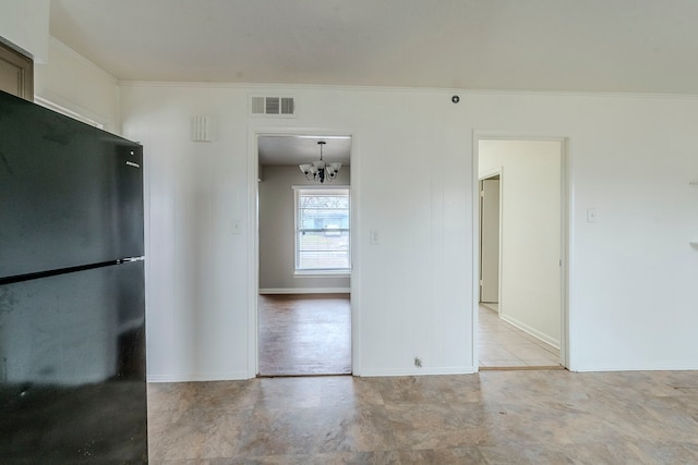 spare room with crown molding and a chandelier