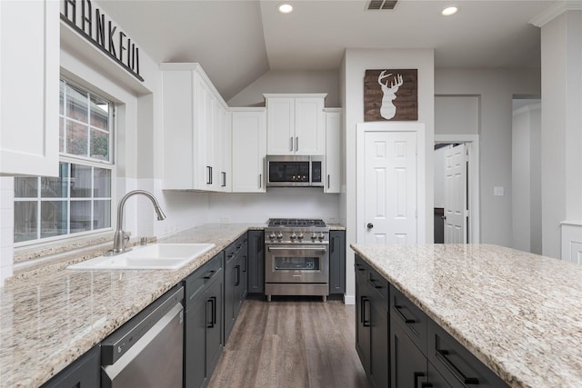 kitchen with sink, tasteful backsplash, appliances with stainless steel finishes, light stone countertops, and white cabinets