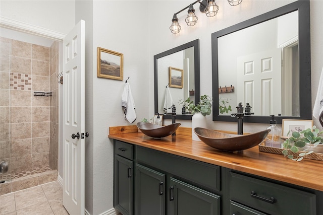 bathroom featuring vanity, tiled shower, and tile patterned floors