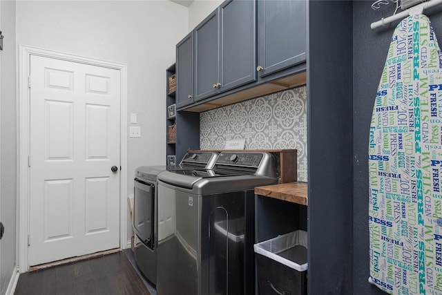 laundry area featuring cabinets, washing machine and dryer, and dark hardwood / wood-style flooring