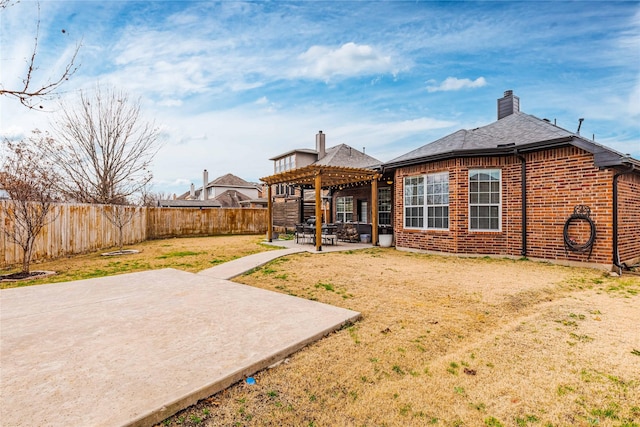 back of property with a pergola, a lawn, and a patio