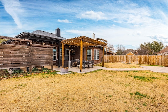 back of property with a patio, a yard, and a pergola