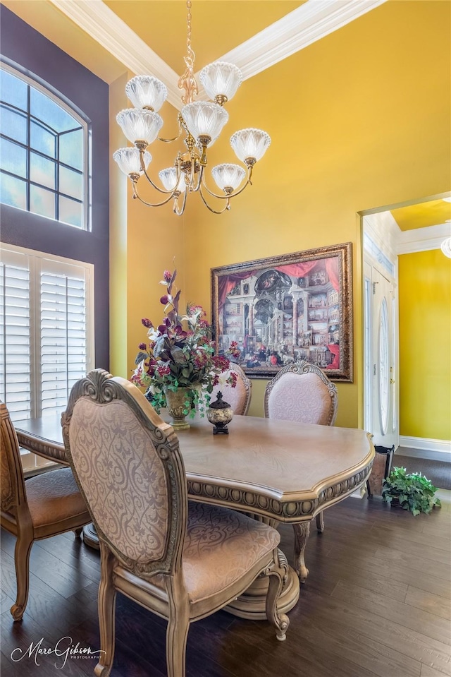 dining room with wood-type flooring, ornamental molding, and a chandelier