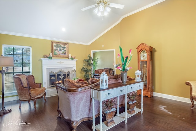 living room featuring dark hardwood / wood-style flooring, vaulted ceiling, ornamental molding, and ceiling fan