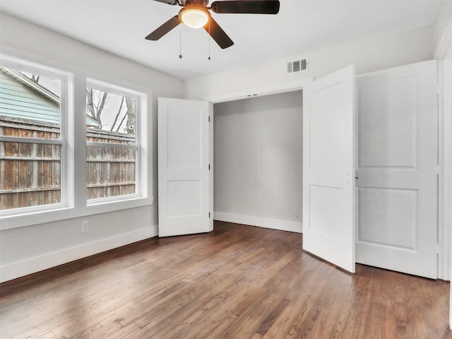 unfurnished bedroom featuring dark wood-type flooring and ceiling fan