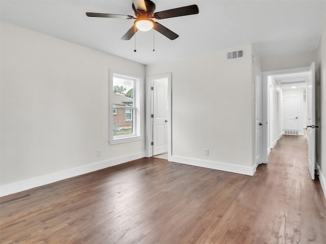 empty room with dark wood-type flooring and ceiling fan