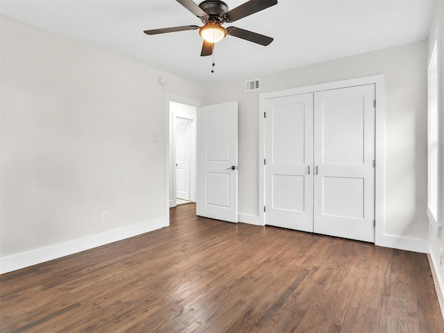 unfurnished bedroom with a closet, dark hardwood / wood-style floors, and ceiling fan