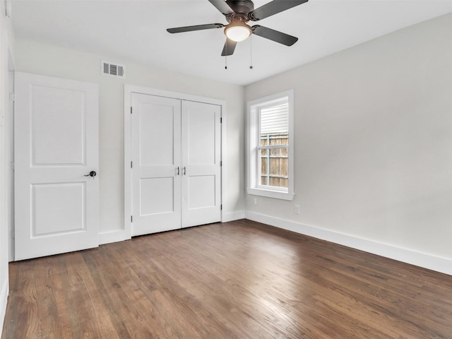 unfurnished bedroom featuring ceiling fan, wood-type flooring, and a closet