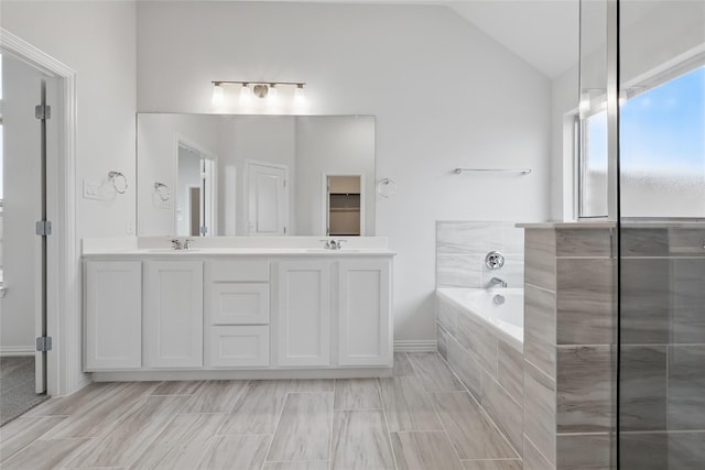 16109 Garden Dr, Celina, TX 75009 - bathroom with a garden tub, double vanity, a sink, and lofted ceiling