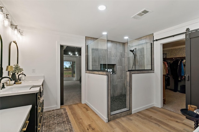 bathroom featuring hardwood / wood-style flooring, vanity, and a tile shower