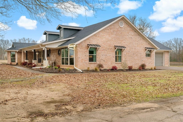 view of side of home with brick siding, roof with shingles, driveway, and a garage