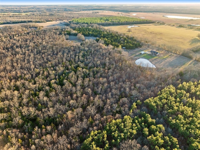 drone / aerial view featuring a rural view and a view of trees